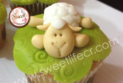Cupcake cubierto con pasta australiana de color verde que lleva en la parte superior una ovejita en 3D